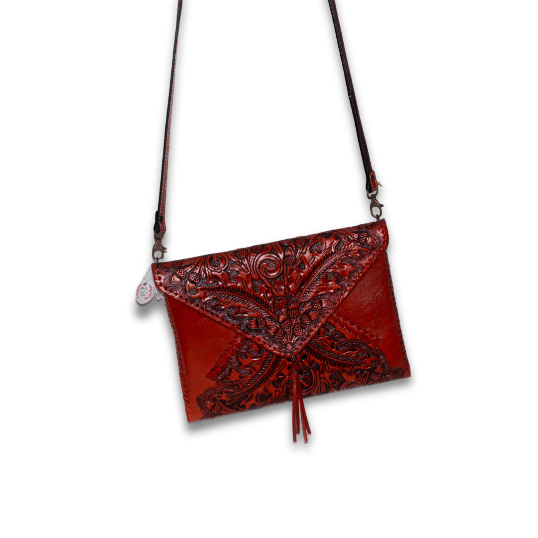 Bolsa tipo sobre de piel roja con grabado floral y correa larga